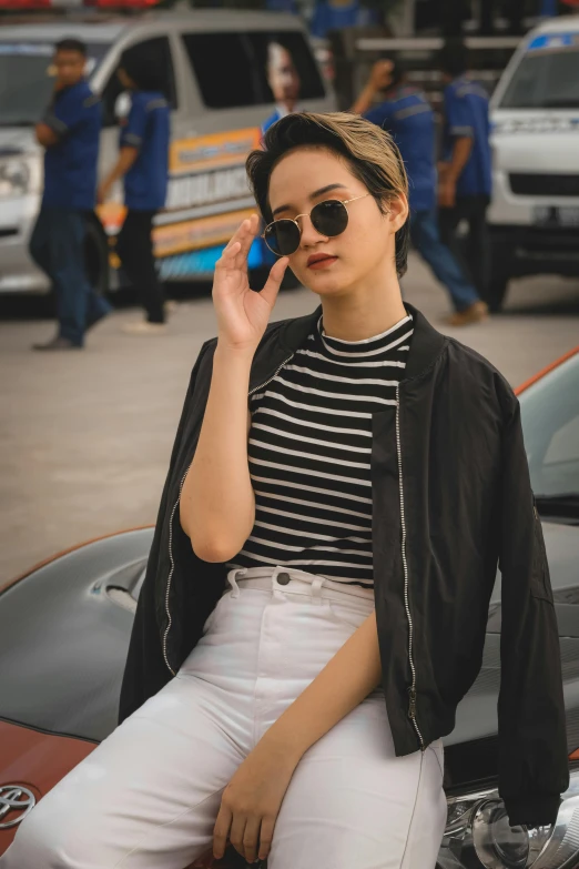 a woman sitting on a car talking on a cell phone, pexels contest winner, photorealism, black stripes, cute casual streetwear, round sunglasses, cropped shirt with jacket