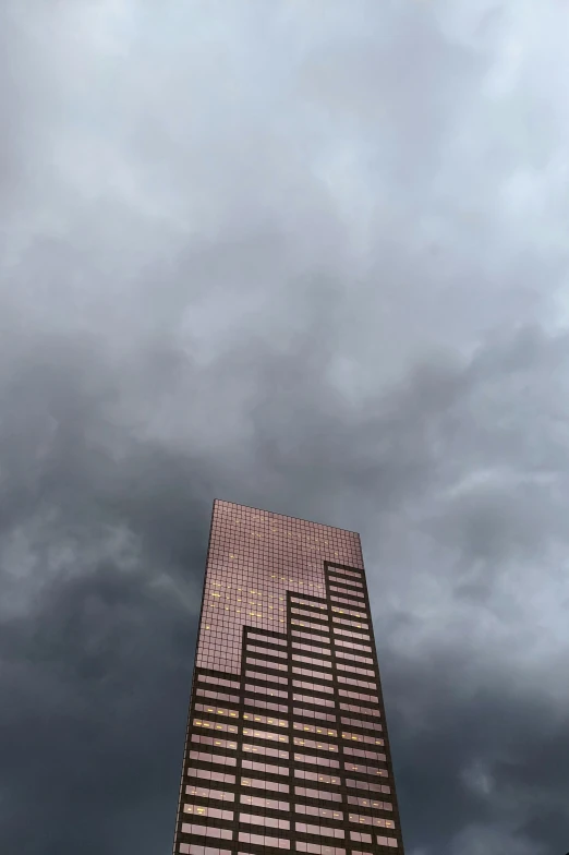 a tall building with a cloudy sky in the background, an album cover, copper, ap news photo, dark overcast weather, minneapolis
