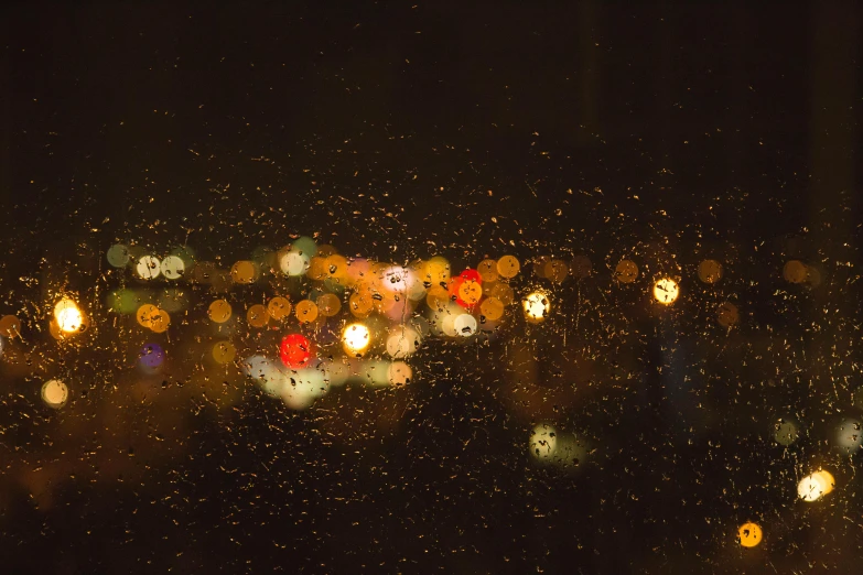 a view of a city through a rainy window, pexels contest winner, visual art, car lights, orange lights, boke, nighttime