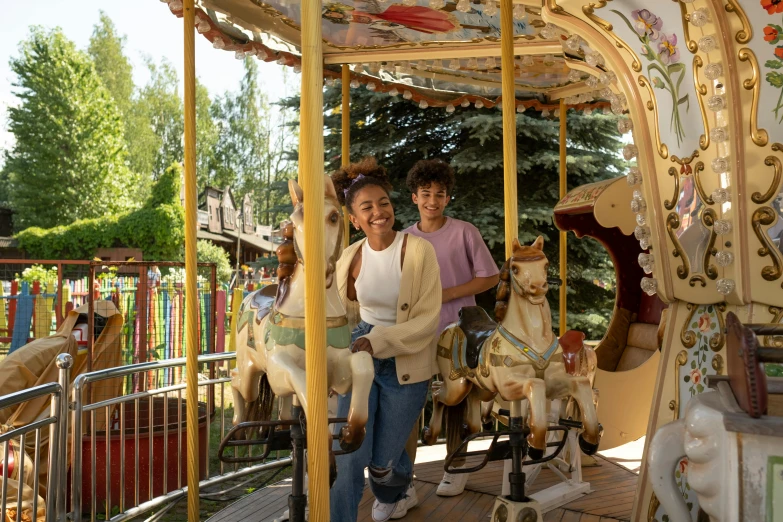 a couple of people riding on top of a carousel, bridge to terabithia, woodland village, vintage vibe, sunny environment