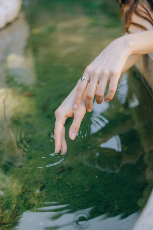 a woman reaching for a fish in a pond, inspired by Elsa Bleda, unsplash, renaissance, ring, water caustics, small