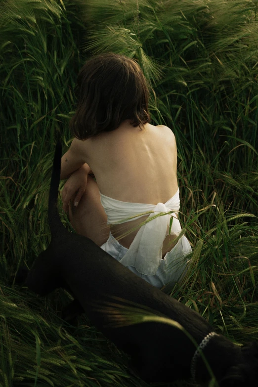 a woman sitting in a field of tall grass, inspired by Andrew Wyeth, unsplash, renaissance, bare back, ignant, animals, embracing