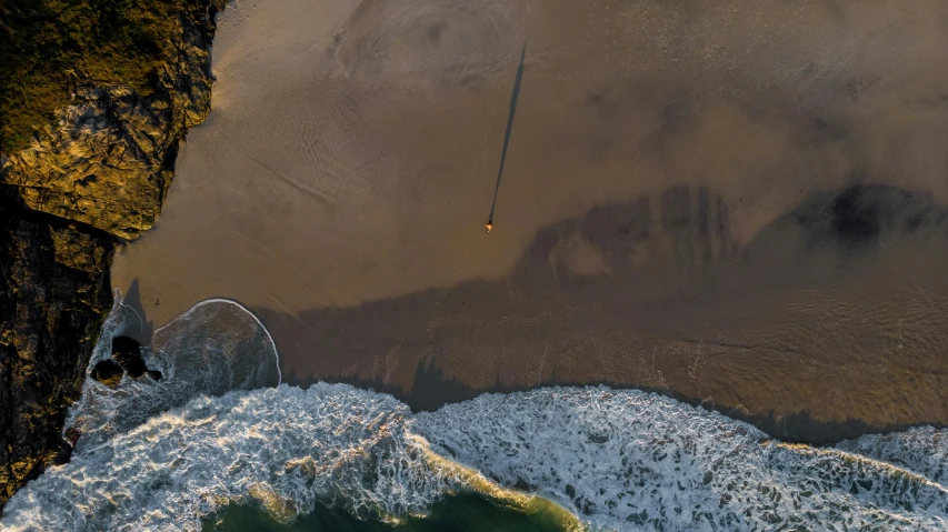 a man standing on top of a cliff next to the ocean, by Eglon van der Neer, unsplash contest winner, land art, airplanes bombing the beach, satellite view, launch of a rocket, golden hour in pismo california