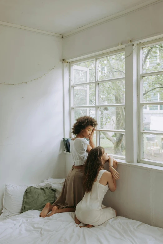 a couple of women sitting on top of a bed, pexels contest winner, light and space, looking through a window frame, kids playing, woman holding another woman, calmly conversing 8k