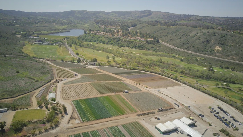 an aerial view of a farm with a lake in the background, malibu canyon, hydroponic farms, spacehip lands, dan eder