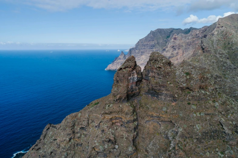 a view of the ocean from the top of a mountain, by Daniel Lieske, pexels contest winner, les nabis, asymmetrical spires, brown, thumbnail, view from helicopter