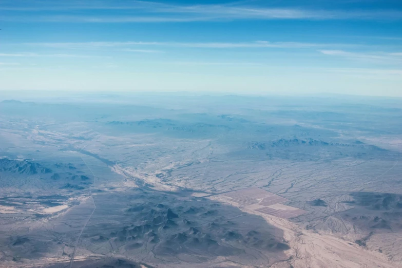 a view of the mountains from an airplane, by Ryan Pancoast, pexels contest winner, visual art, mojave desert, thumbnail, blue sky, dry river bed