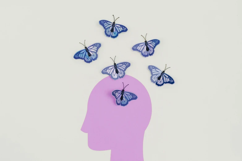 a woman's head with butterflies flying out of it, by Rachel Reckitt, conceptual art, mini model, blue and violet, but minimalist, monarch butterflies