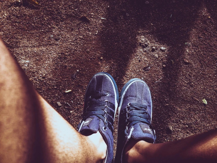 a close up of a person's feet and shoes, a picture, unsplash, dark blue clothes, wearing shorts, avatar image, lomo