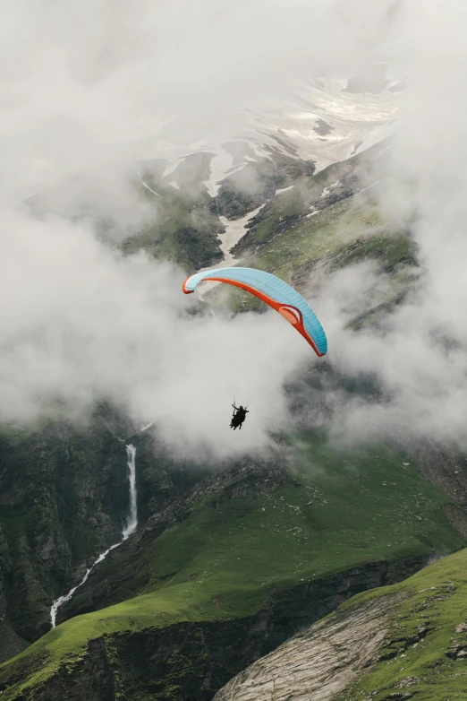 a person paragliding in the mountains on a cloudy day, by Daren Bader, hurufiyya, 9 9 designs, high angle uhd 8 k, glaciers, wide high angle view