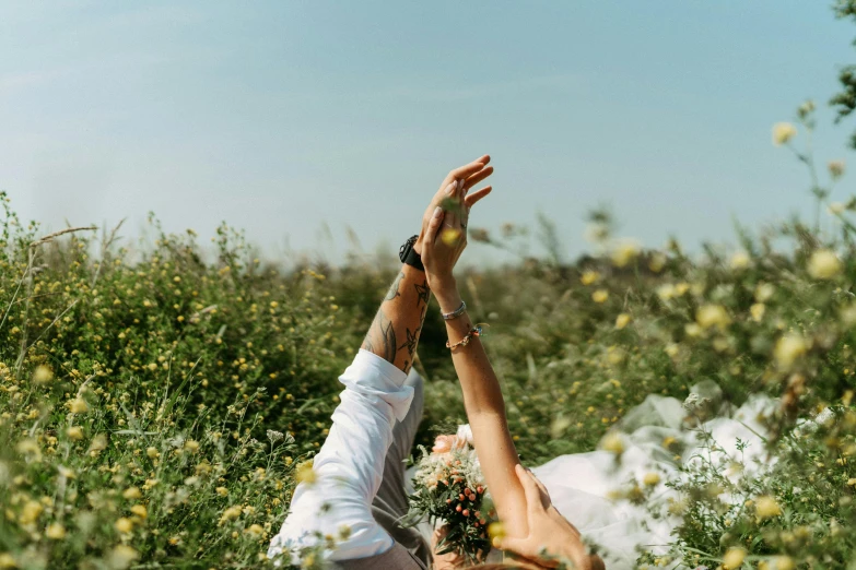 a man and a woman laying in a field of flowers, by Emma Andijewska, pexels contest winner, hands in air, wedding, working out in the field, unfinished