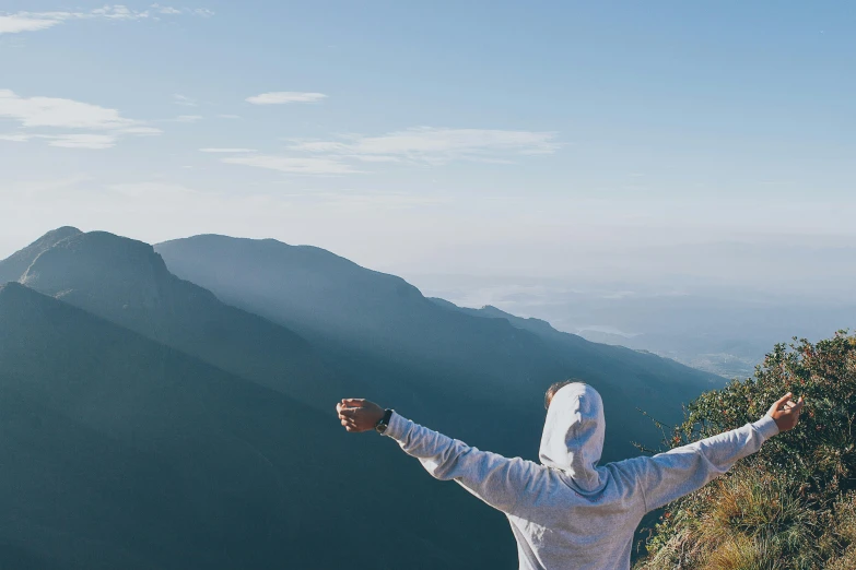 a man standing on top of a mountain with his arms outstretched, pexels contest winner, panoramic view of girl, highly relaxed, waving, profile pic