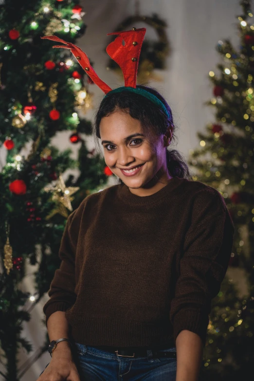 a woman sitting in front of a christmas tree, with brown skin, short antlers, promo image, multiple stories