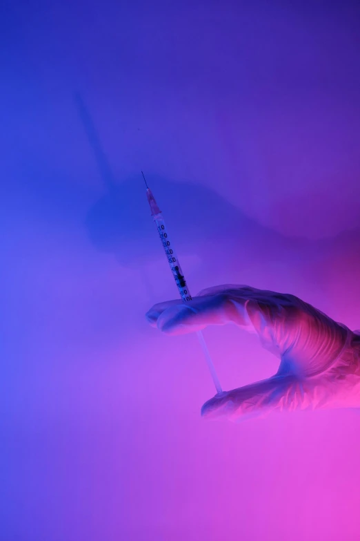 a close up of a person's hand holding a needle, blue and purple lighting, steroid use, syringe, trending photo