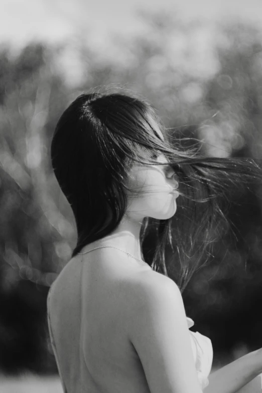 a black and white photo of a woman with her hair blowing in the wind, by Shang Xi, noseless, girl with black hair, ((portrait)), amidst nature