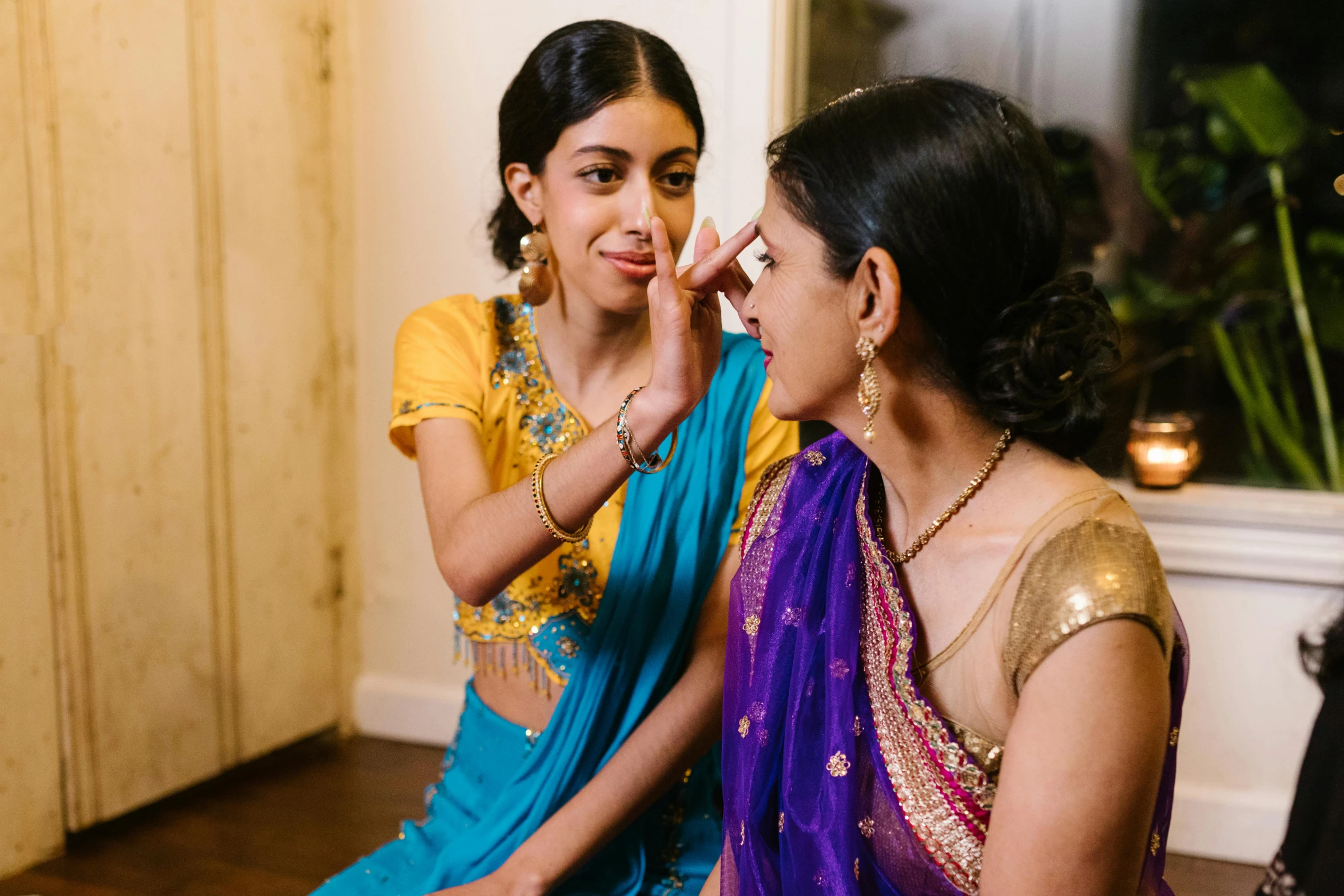 a couple of women sitting next to each other, a portrait, by Alice Mason, pexels contest winner, hurufiyya, putting makeup on, dressed in a sari, thumbnail, close up half body shot