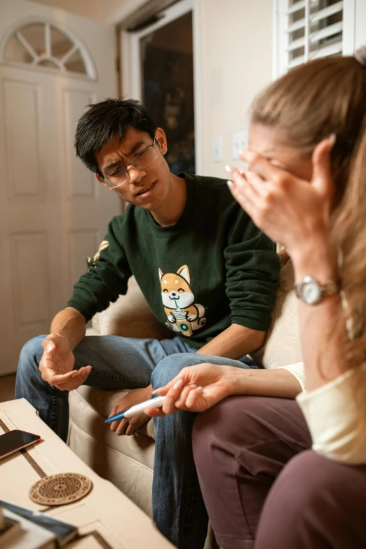 a couple of people that are sitting on a couch, he is wearing a brown sweater, talking, david luong, clinically depressed