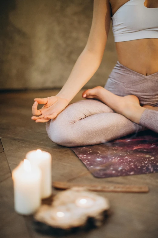 a woman sitting on a yoga mat in front of a candle, trending on pexels, renaissance, sitting with wrists together, professional photo, pastels, 15081959 21121991 01012000 4k