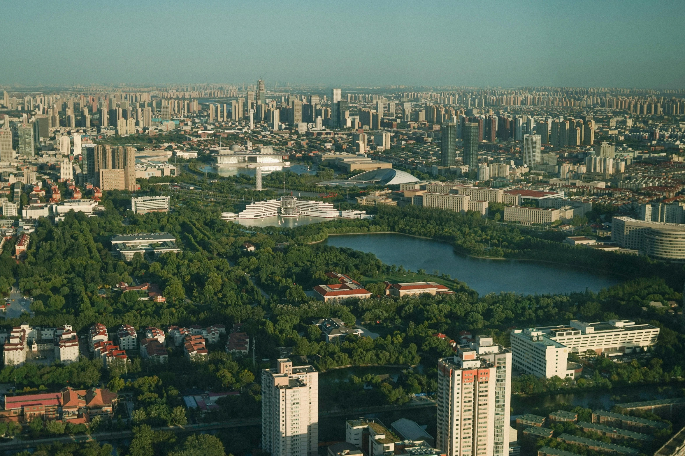 a view of a city from a tall building, by Zha Shibiao, pexels contest winner, gutai group, parks and lakes, highly detailed image, slight haze, high resolution photograph