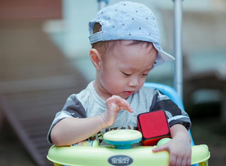 a little boy that is playing with a toy, pexels contest winner, carrying a tray, square, sitting in his highchair, cardistry