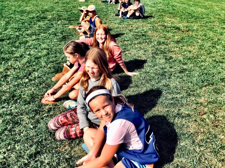 a group of young girls sitting on top of a lush green field, summer camp, iphone photo, perfect crisp sunlight, for aaa game