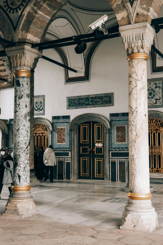 a group of people standing inside of a building, inspired by Osman Hamdi Bey, trending on unsplash, arabesque, marble room, entrance, square, grey