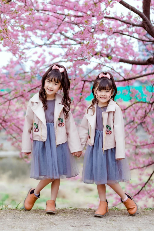 two little girls standing next to each other in front of a tree, instagram, 中 元 节, purple and pink leather garments, cherry blossom, avatar image