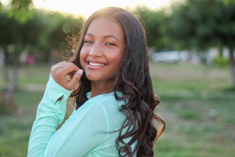 a beautiful young woman holding a cell phone to her ear, by Gwen Barnard, unsplash, indian girl with brown skin, light green tone beautiful face, 1 6 years old, happily smiling at the camera