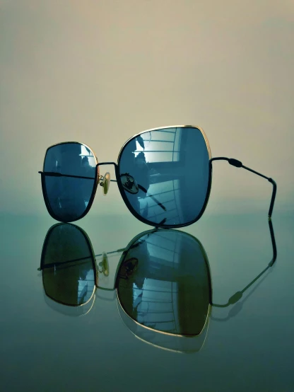 a pair of sunglasses sitting on top of a table, a picture, by Andrei Kolkoutine, unsplash, photorealism, black gold light blue, cinematic. by leng jun, beautiful reflexions, square glasses