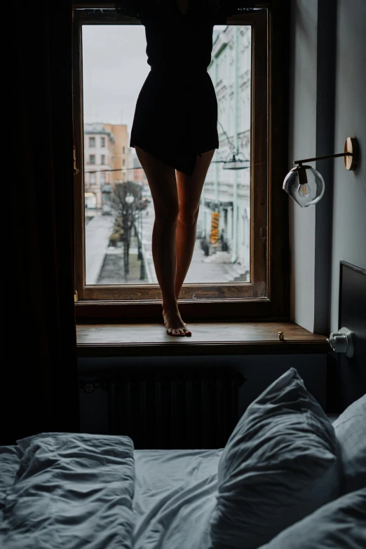 a woman standing on top of a bed next to a window, inspired by Elsa Bleda, unsplash contest winner, shows a leg, staring seductively, early morning mood, massive legs towering over you