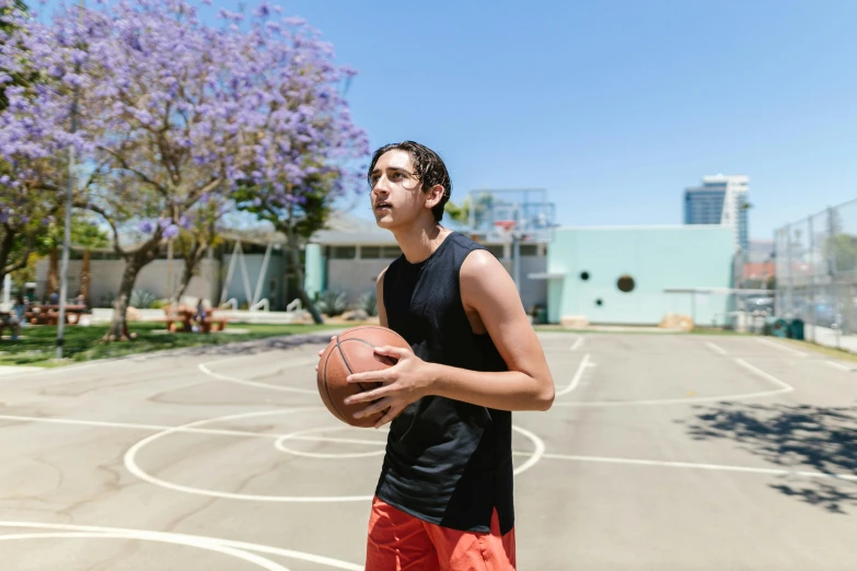 a man standing on a basketball court holding a basketball, by Gavin Hamilton, dribble, lachlan bailey, profile image, finn wolfhard, on a bright day