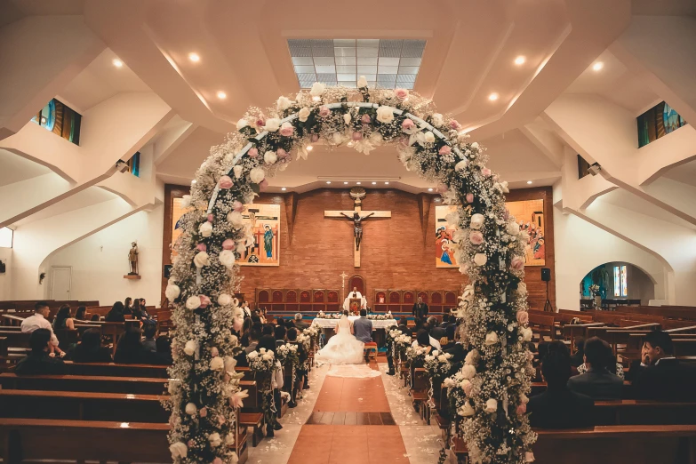 a bride and groom walking down the aisle of a church, a picture, by Robbie Trevino, unsplash, romanticism, flower decorations, massive arch, deity), 2 0 0 0's photo