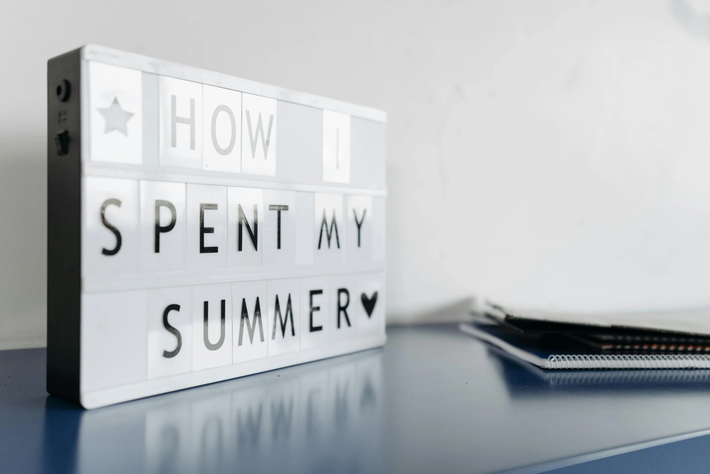 a white lightbox sitting on top of a blue table, pexels contest winner, summer time, typographical experiments, taken from the high street, blow my mind