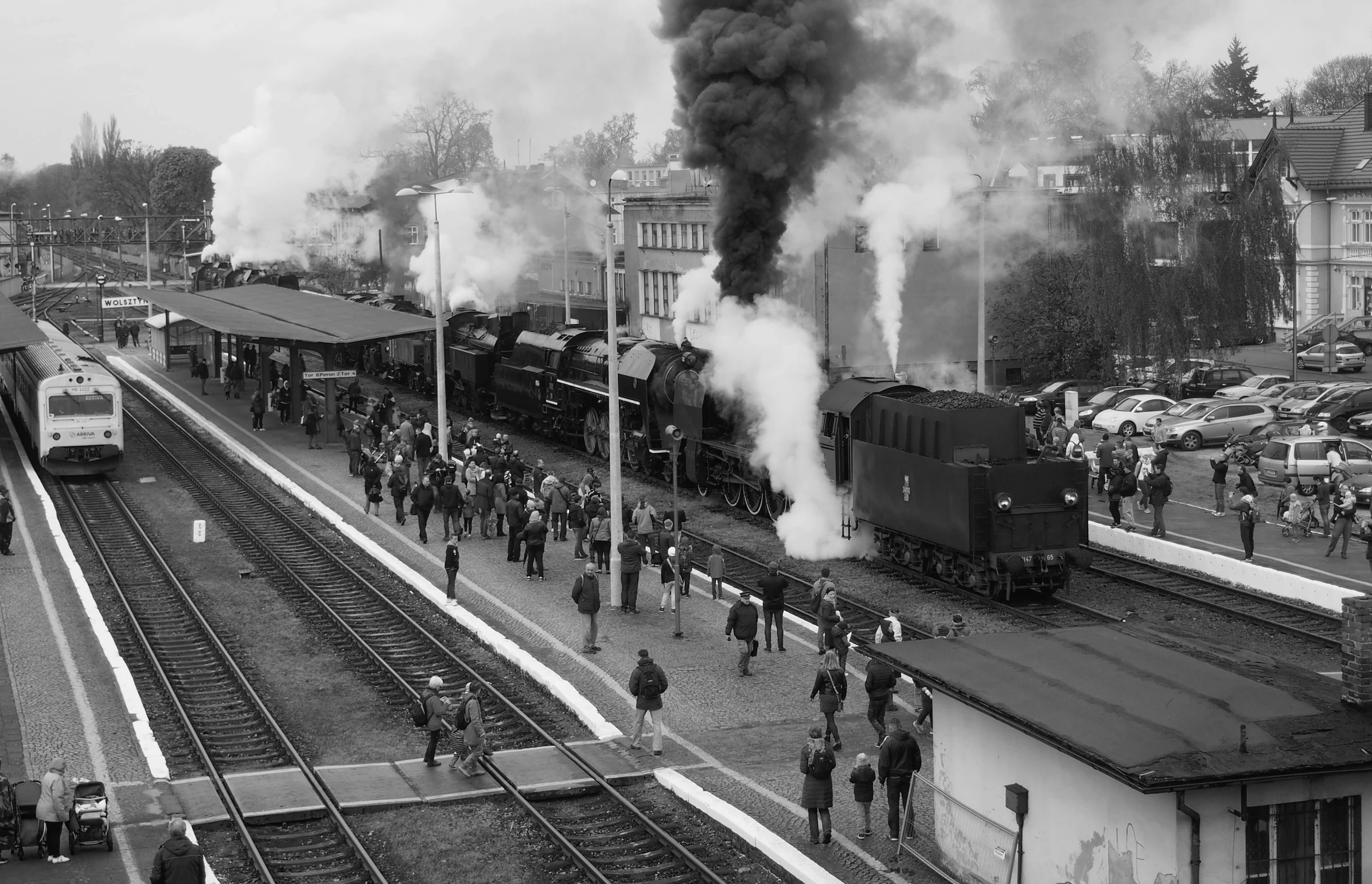 a black and white photo of a train pulling into a train station, by Kev Walker, thick black smoke billowing, crowded and populated, strathmore 2 0 0, round about to start