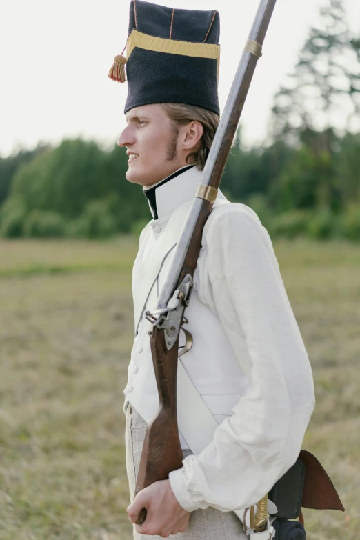 a man in uniform holding a rifle in a field, inspired by Eero Järnefelt, unsplash, renaissance, white russian clothes, side profile view, live-action archival footage, finland