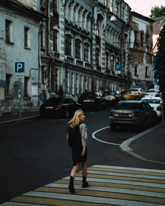 a woman walking across a crosswalk on a city street, by Emma Andijewska, unsplash contest winner, renaissance, photo of putin, blonde women, lgbtq, parking in the street