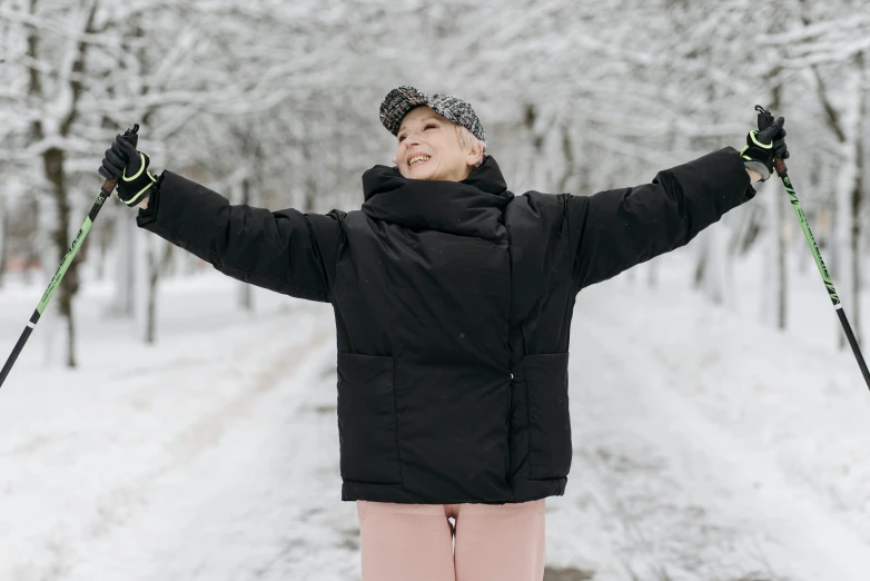 a woman standing in the snow with her arms in the air, pexels contest winner, jet black tuffe coat, greta thunberg smiling, puffer jacket, wearing festive clothing