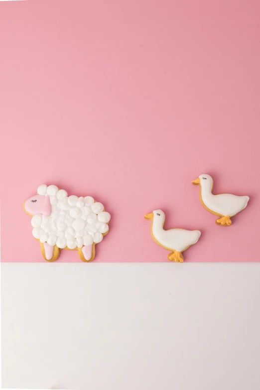 three cookies in the shape of animals on a pink and white background, a picture, by Paul Bird, shutterstock contest winner, cute goose, farming, bright white porcelain, jen atkin