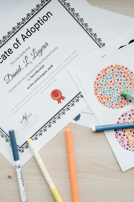 a certificate sitting on top of a wooden table, a child's drawing, academic art, colouring - in sheet, mandalas, light scatter, 3 colour print