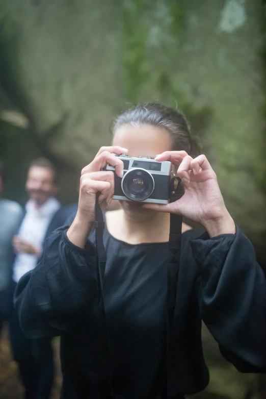 a woman taking a picture with a camera, style of joel meyerowitz, grey, medium format, adventure