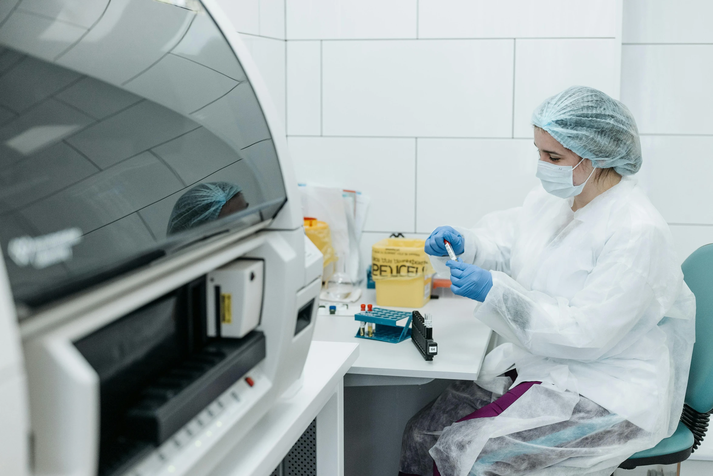 a person sitting at a desk in a lab, sterile colours, plating, luxury equipment, thumbnail