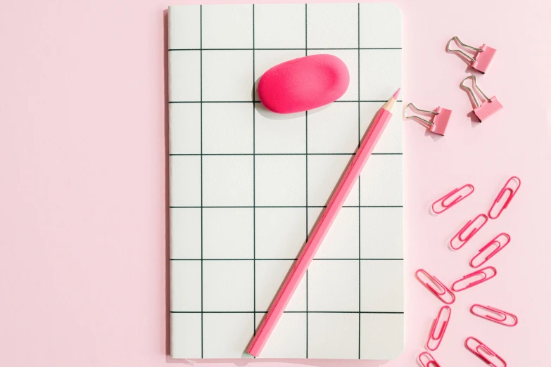 a pink pen sitting on top of a piece of paper, inspired by Patrick Caulfield, trending on pexels, minimalism, squares, bubblegum body, notebook, modelling clay