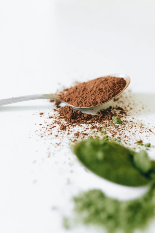 a spoon with some powder on top of it, by Andries Stock, trending on pexels, mint leaves, fully chocolate, on a white table, iron