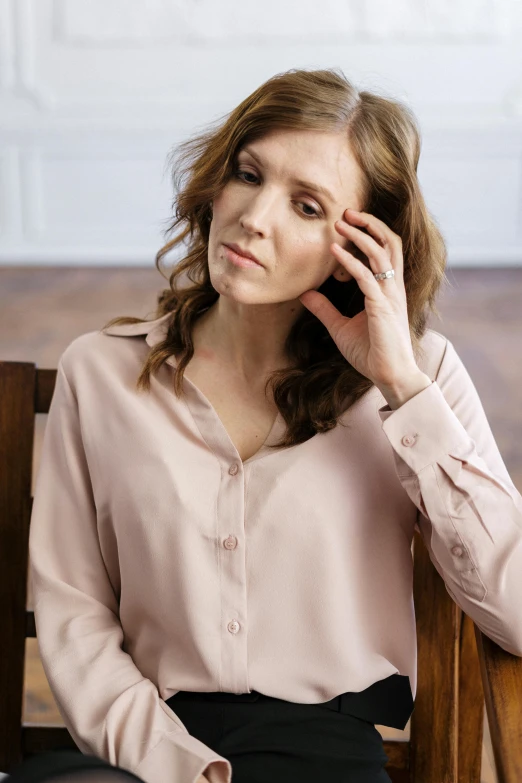 a woman sitting in a chair talking on a cell phone, loose - fitting blouses, soft blush, she's sad, full product shot