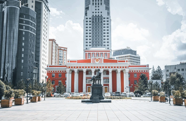 a red building with a statue in front of it, pexels contest winner, socialist realism, kazakh empress, many skyscrapers, white building, square