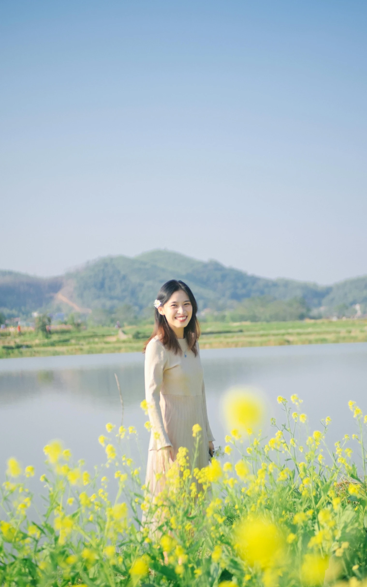 a woman standing in a field of yellow flowers, by Tan Ting-pho, low quality photo, river in the background, avatar image, full body photo