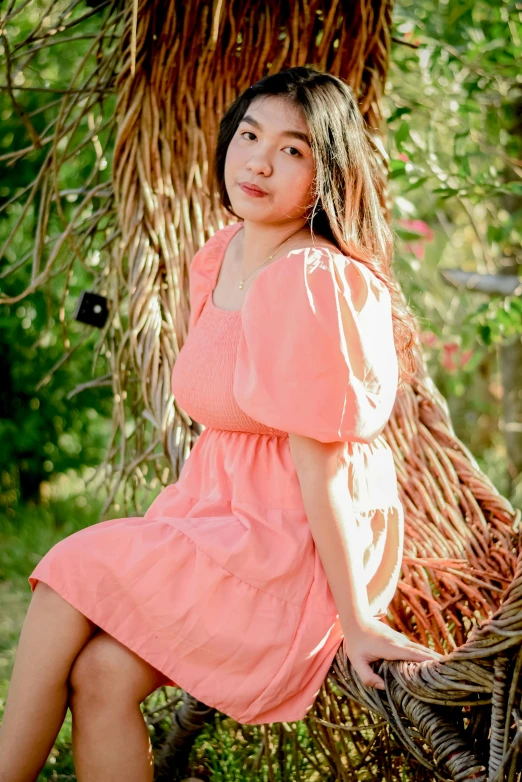 a woman in a pink dress sitting on a bench, kuntilanak on tree, orange pastel colors, promo photo, thawan duchanee