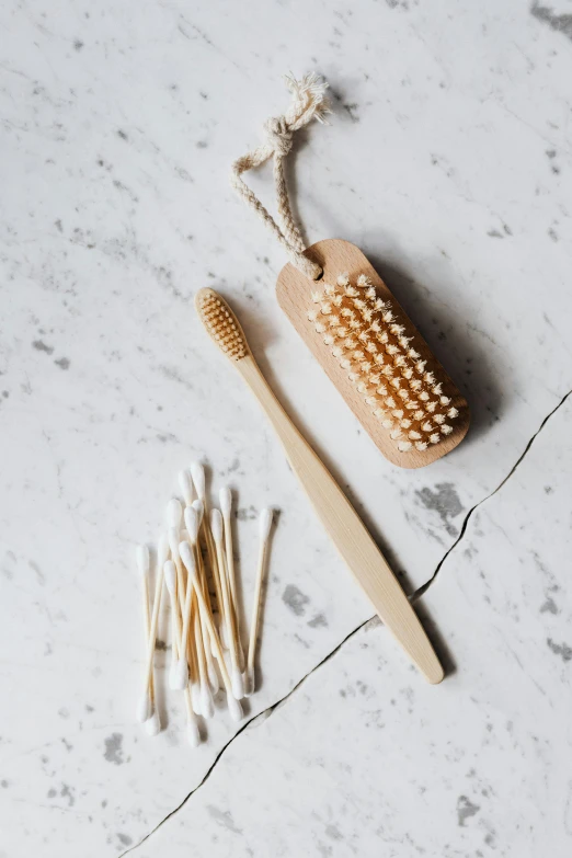 a couple of toothbrushes sitting on top of a table, natural materials, hanging, detailed product image, gold