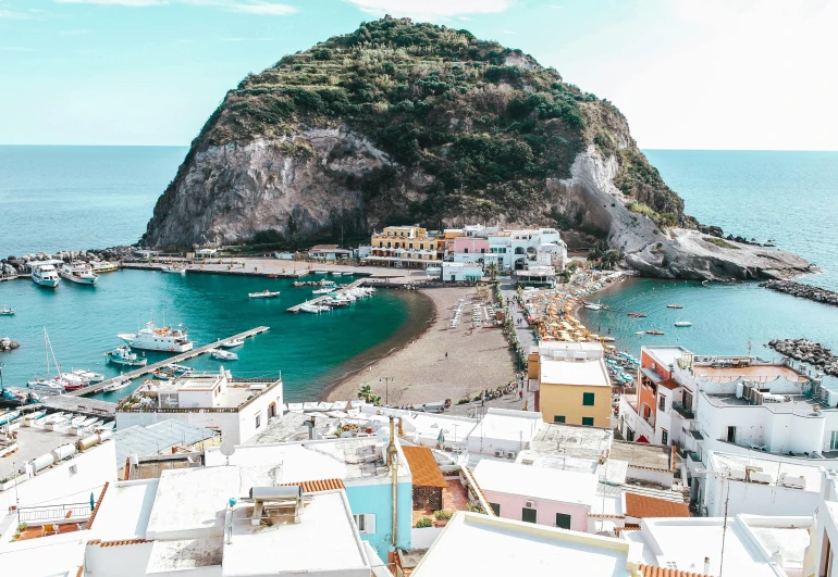 a small island in the middle of a body of water, by Patrick Pietropoli, pexels contest winner, renaissance, small port village, overlooking the beach, in the style wes anderson, vulcano