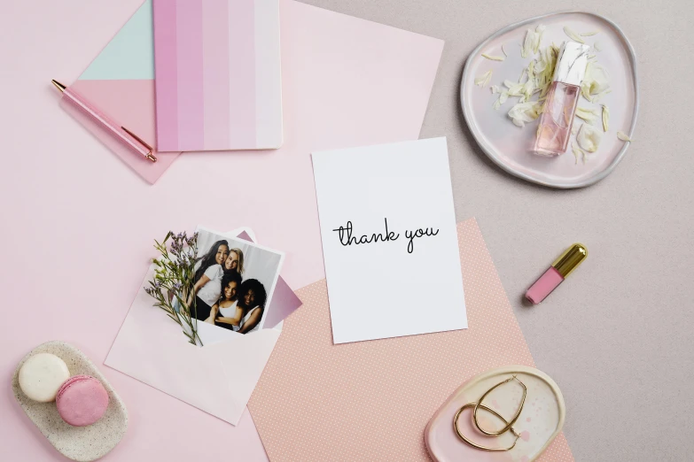 a thank card sitting on top of a pink table, a polaroid photo, inspired by Louis Hersent, vanessa morgan, pastel colour palette, with straight black hair, products shot